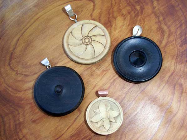 Piccoli oggetti in legno intagliato: medaglioni e pendenti